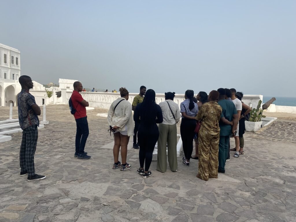 Travelers exploring top places of interest in Ghana at the scenic coast