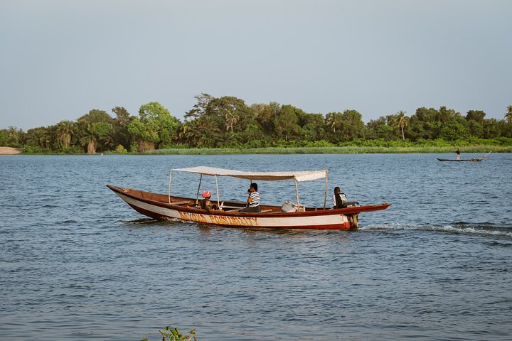 Local boat navigating the waters near crocodile island Ghana