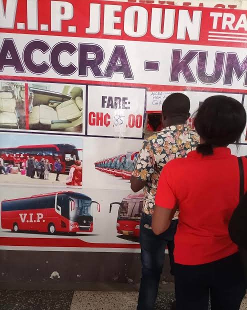Traveler checking the Mankessim to Kumasi fare at a transport station