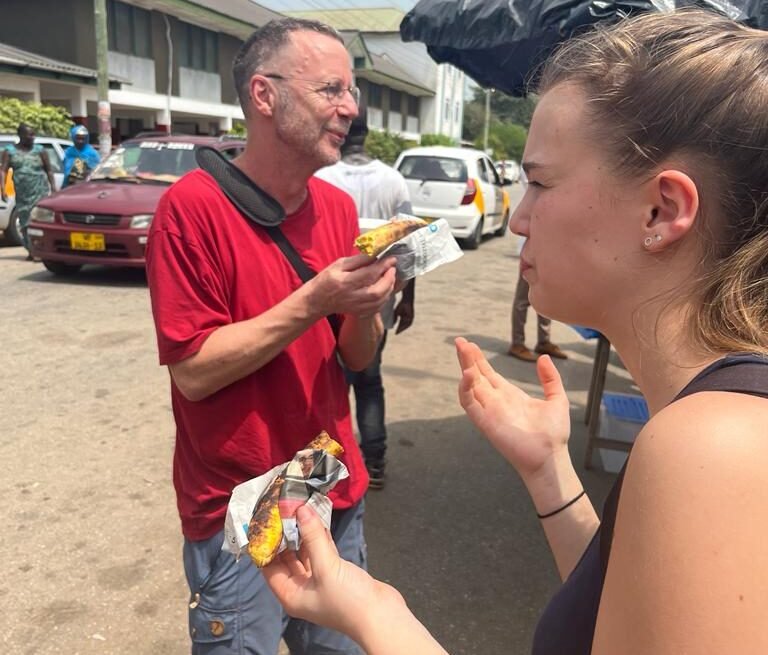 How far does $100 go in Ghana today? A Practical Budget Guide - tourists eating roast plantain